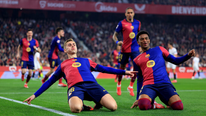 SEVILLE, SPAIN - FEBRUARY 09: Fermin Lopez of FC Barcelona celebrates scoring his team's second goal with teammate Alejandro Balde during the LaLiga match between Sevilla FC and FC Barcelona at Estadio Ramon Sanchez Pizjuan on February 09, 2025 in Seville, Spain. (Photo by Fran Santiago/Getty Images)
