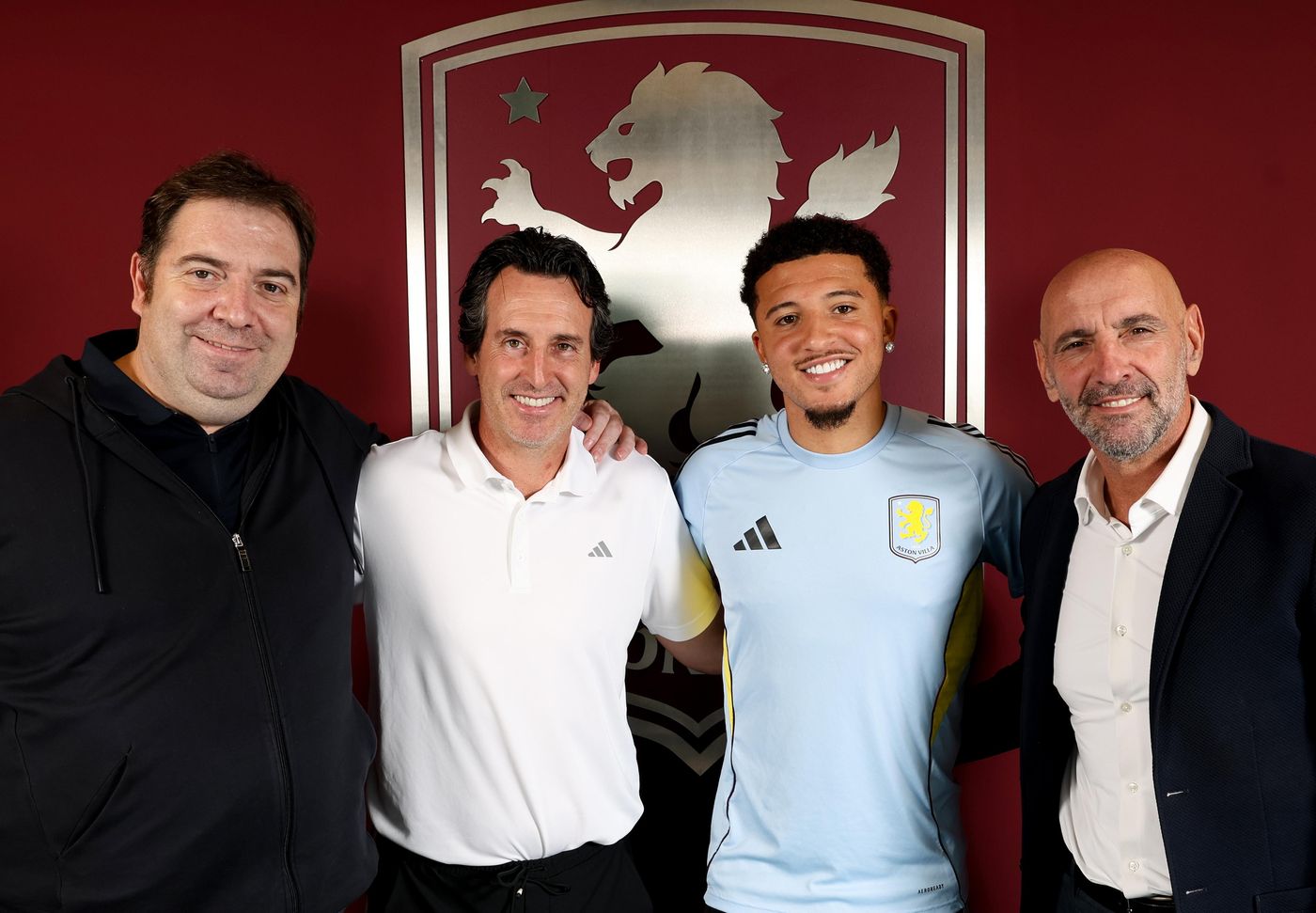 Jadon Sancho smiles alongside Unai Emery after signing for Aston Villa.