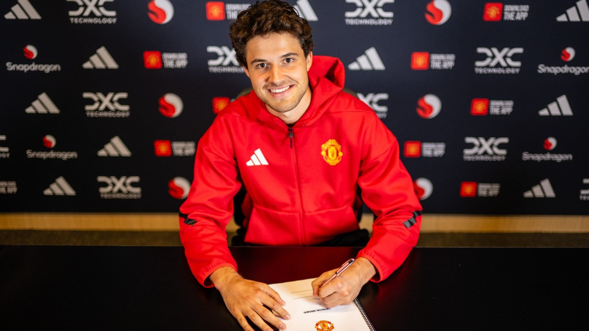Senne Lammens signs his Man United contract.
