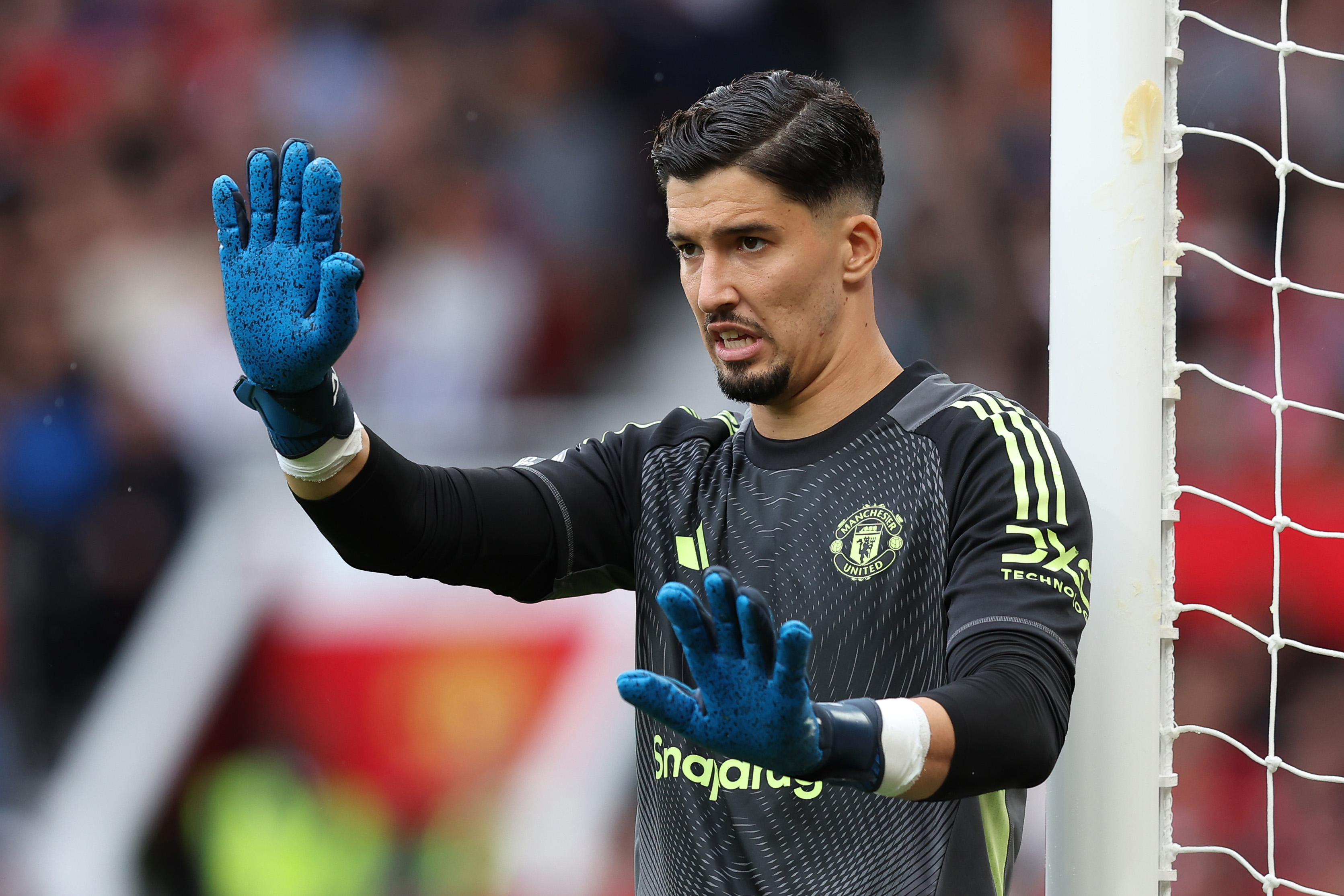 Altay Bayindir signals to his teammates while in net for Man United.