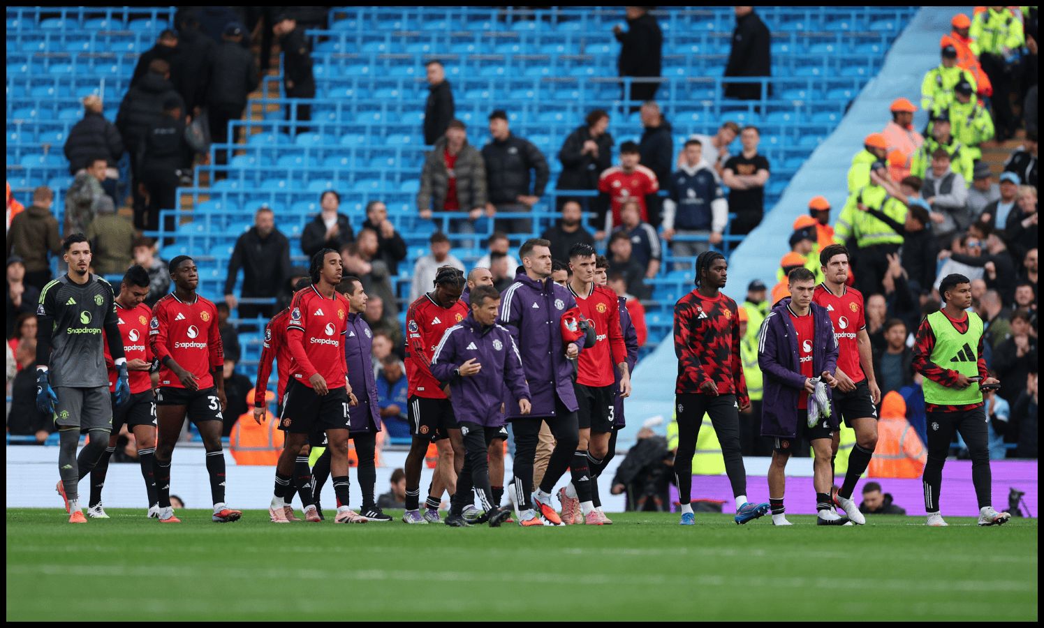 Man United players look dejected after losing to Man City.