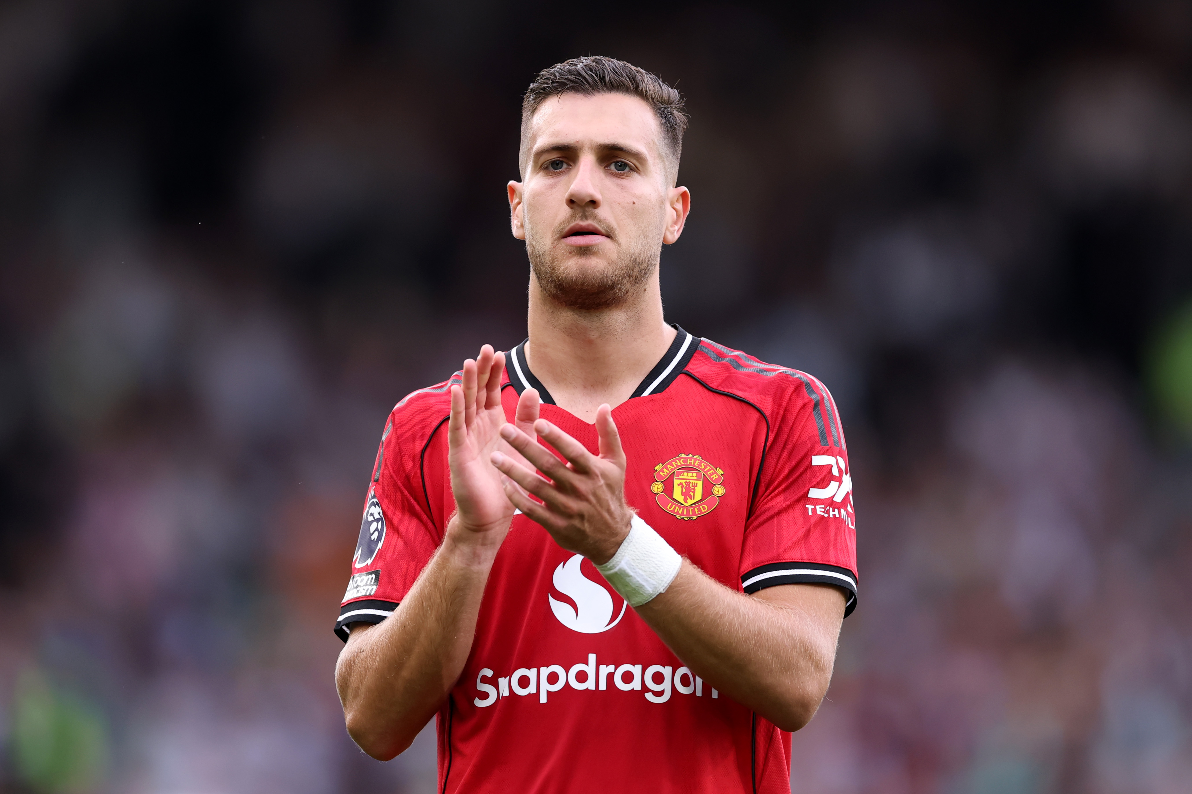 Diogo Dalot applauds the Man United fans at Craven Cottage.