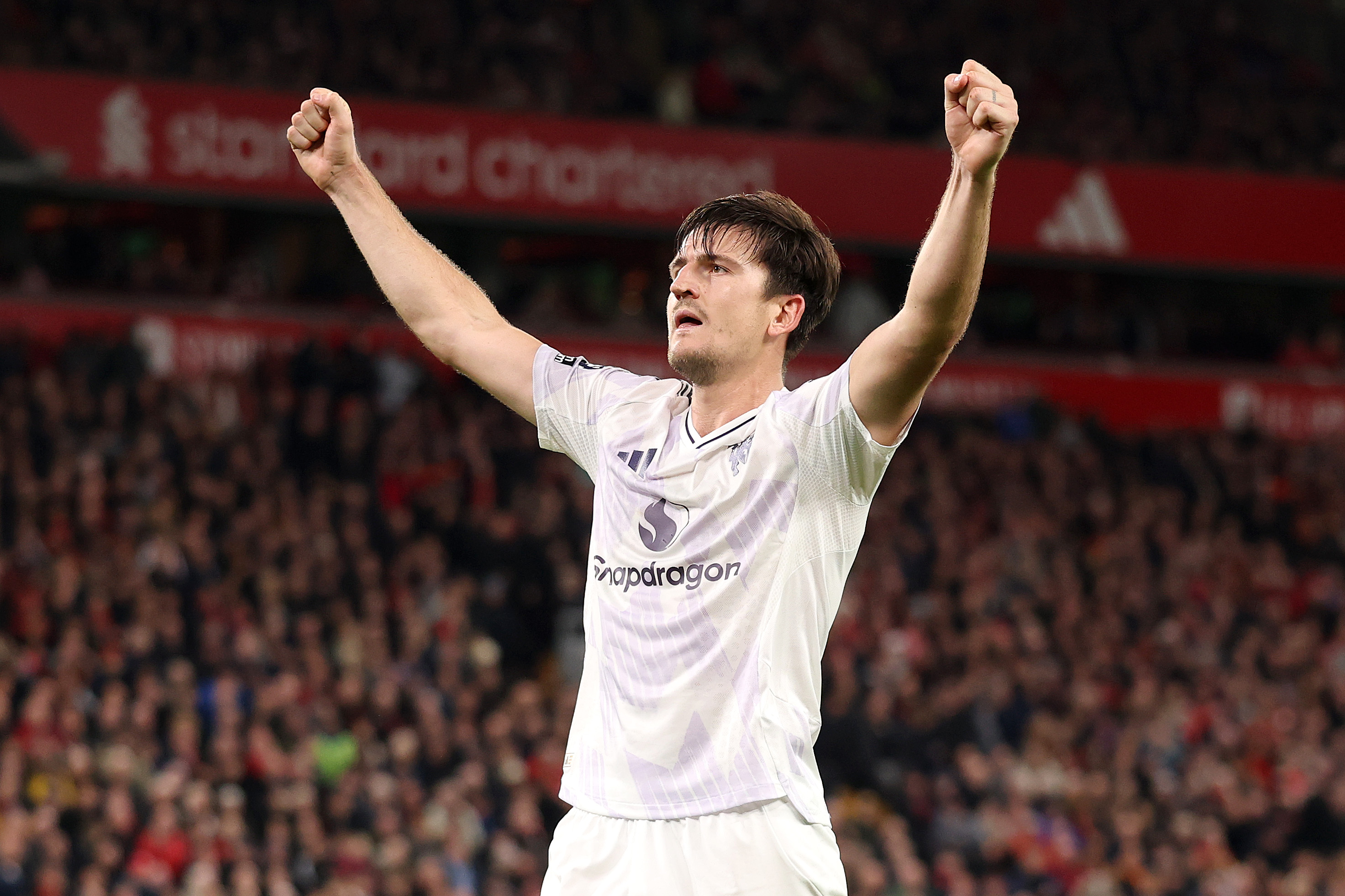Harry Maguire celebrates with Man United fans at Anfield.