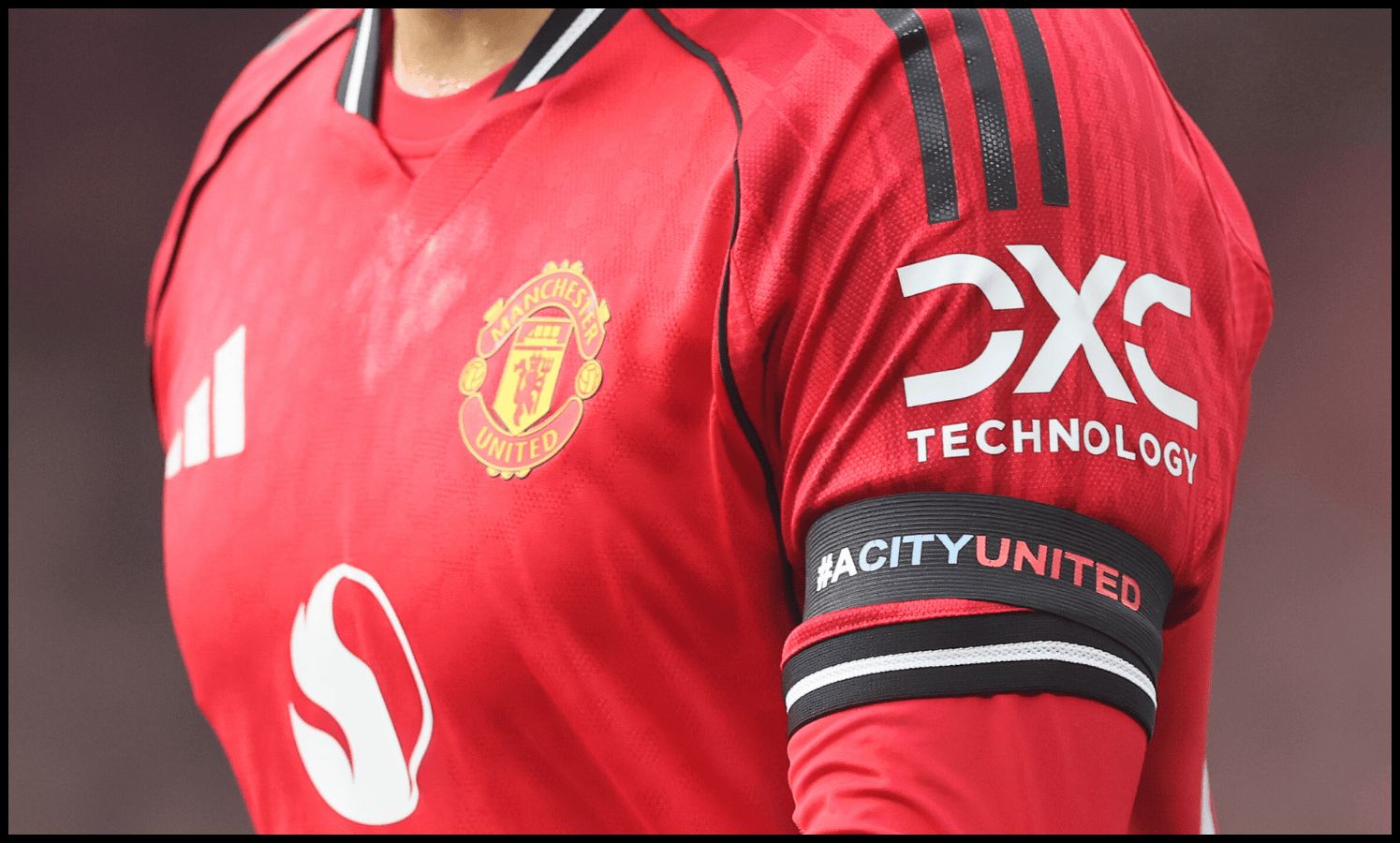 A Man United player dons ‘ACityUnited’ black armband.